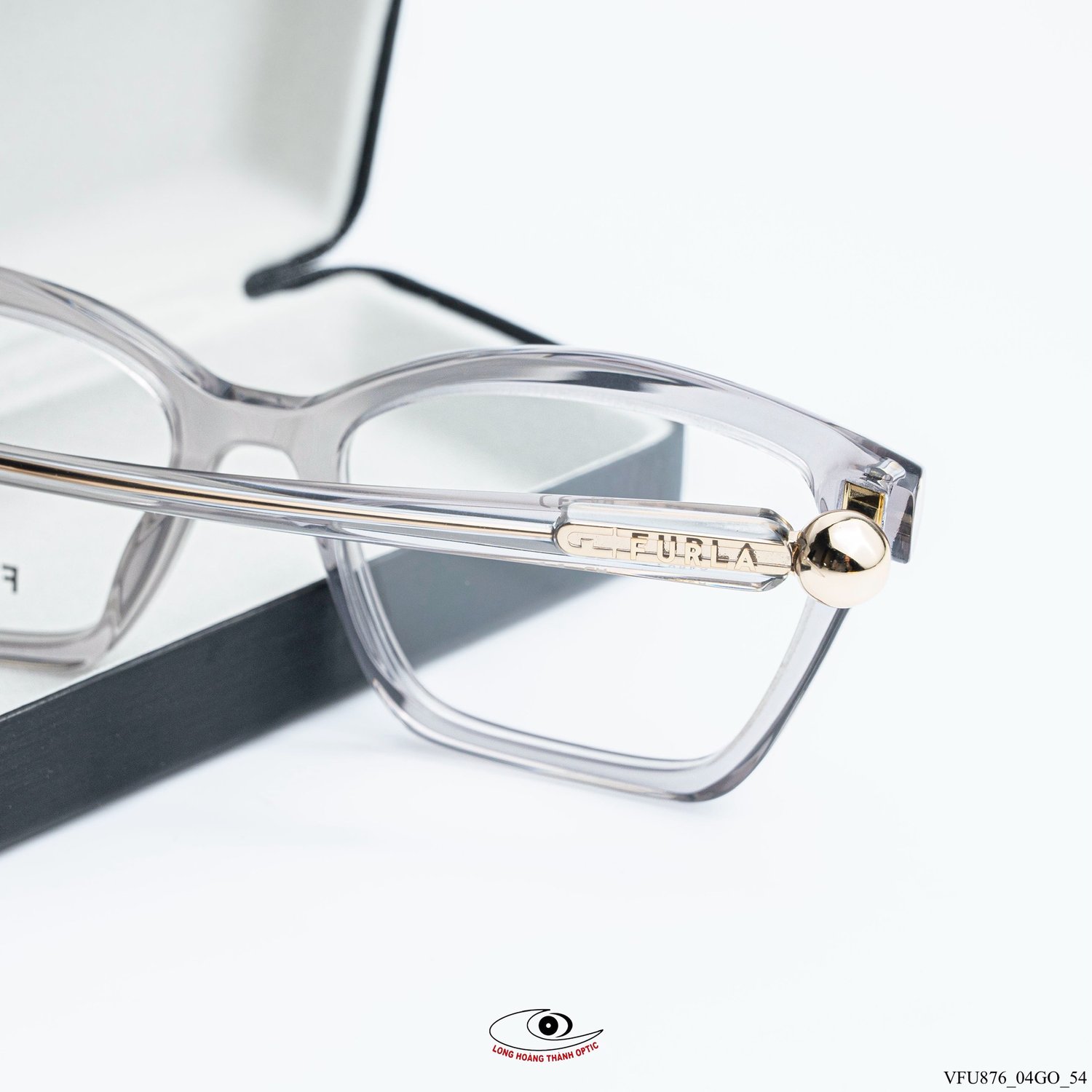 Gọng kính Furla VFU876 Col.04GO dáng mắt mèo hiện đại, chất liệu acetate trong suốt, logo vàng đồng tinh tế, mang đến vẻ thanh lịch.
